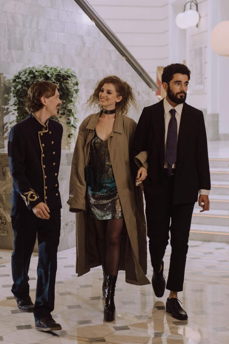 A couple walks with a concierge in a luxurious hotel lobby, showcasing hospitality.